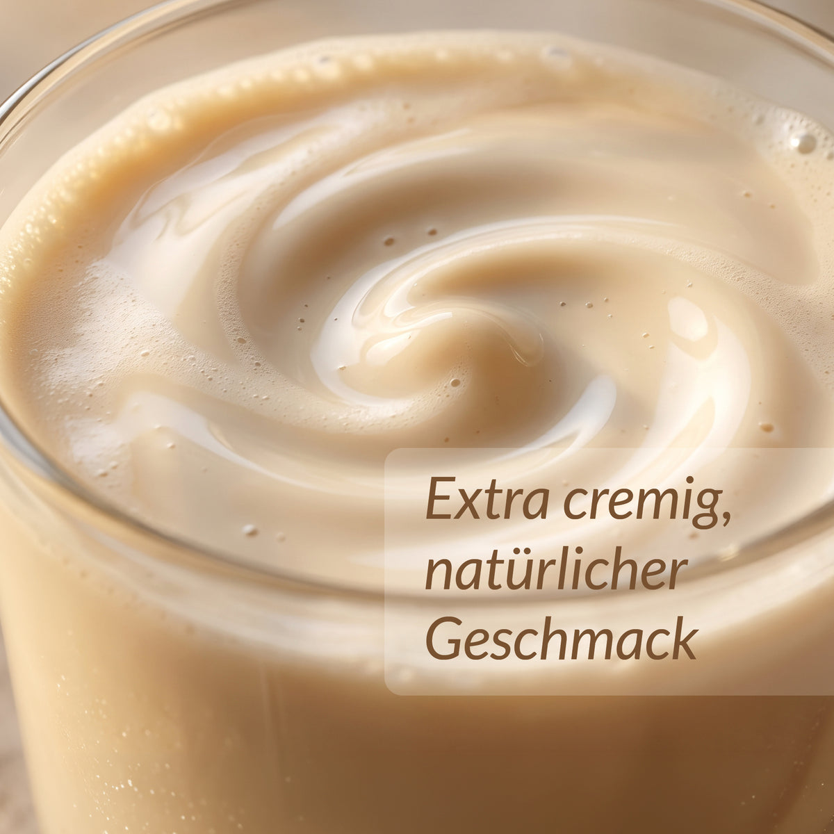 Nahaufnahme eines cremigen Shakes im Glas mit dem eingeblendeten Text „Extra cremig, natürlicher Geschmack“.